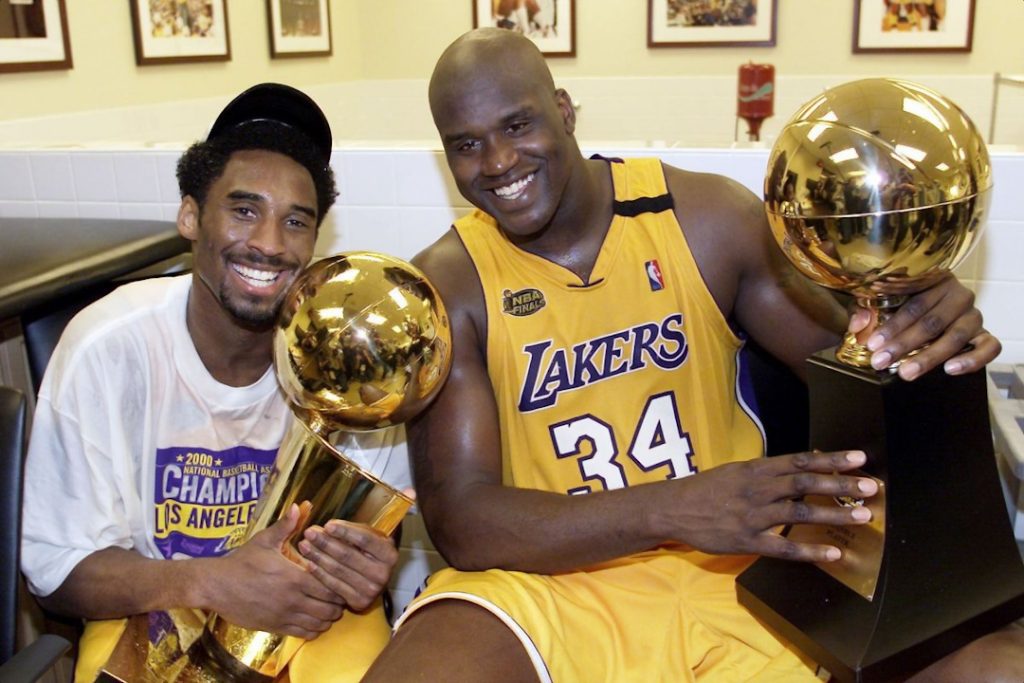 Um jovem Kobe e Shaq posando com seus troféus
