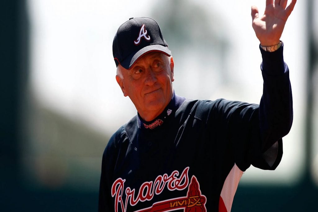 Phil Niekro acena para o público em jogo do Atlanta Braves.