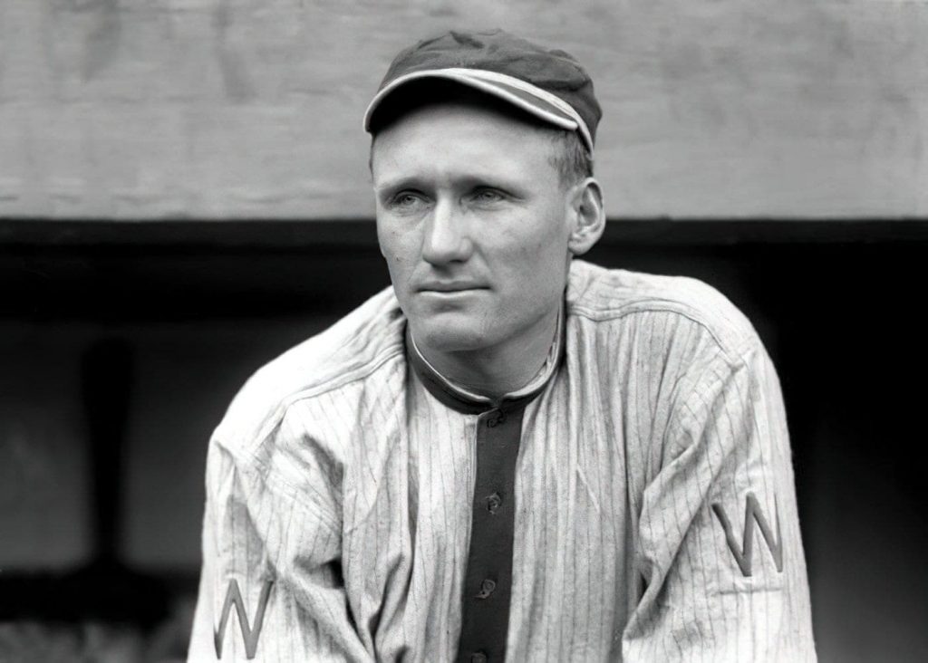 Walter Johnson, o melhor pitcher da MLB, em pé no dugout. 