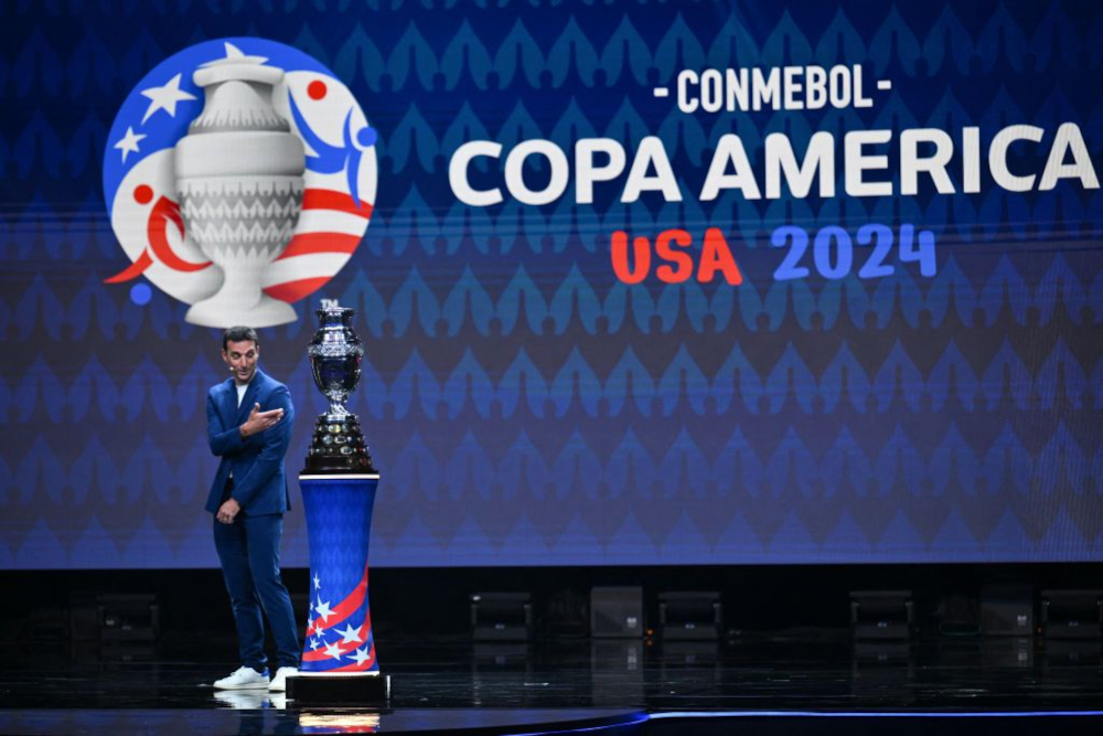 Lionel Scaloni apresenta a taça da Copa América 2024 no palco.