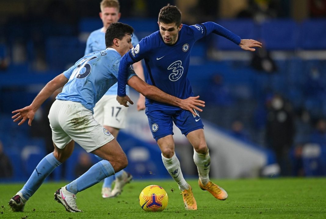 Disputa de bola entre jogadores do Manchester City e Chelsea em partida válida pela Premier League.