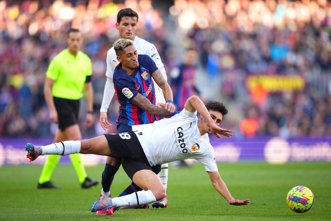 Jogadores de Barcelona e Valencia em disputa de bola durante partida válida pela La Liga.