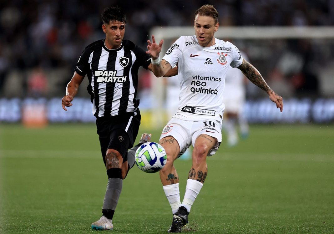 Disputa de bola entre jogadores do Botafogo e do Corinthians em partida válida pelo Campeonato Brasileiro.